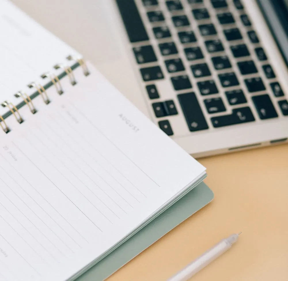 Agenda ouvert à côté d’un ordinateur portable